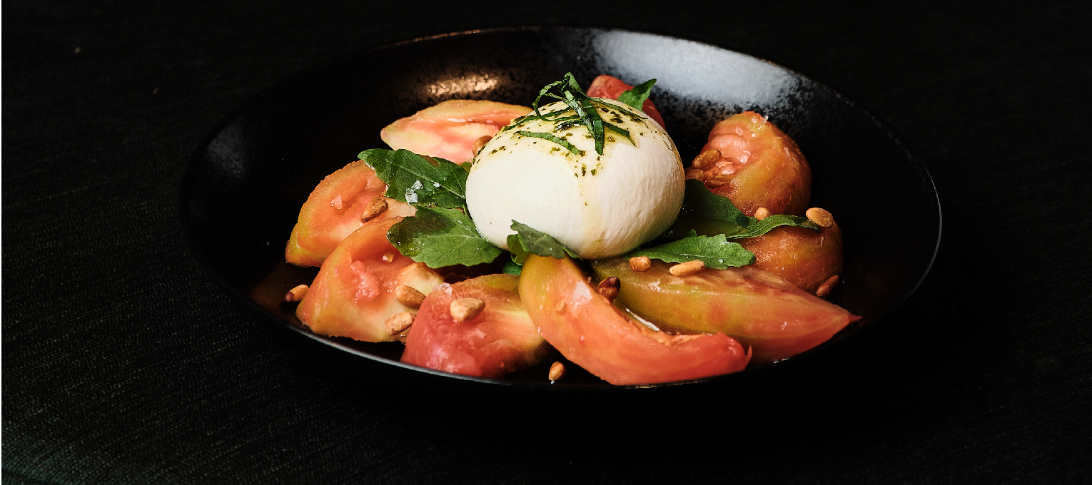 Ensalada de tomate feo de villafranca con burrata, albahaca y piñones.