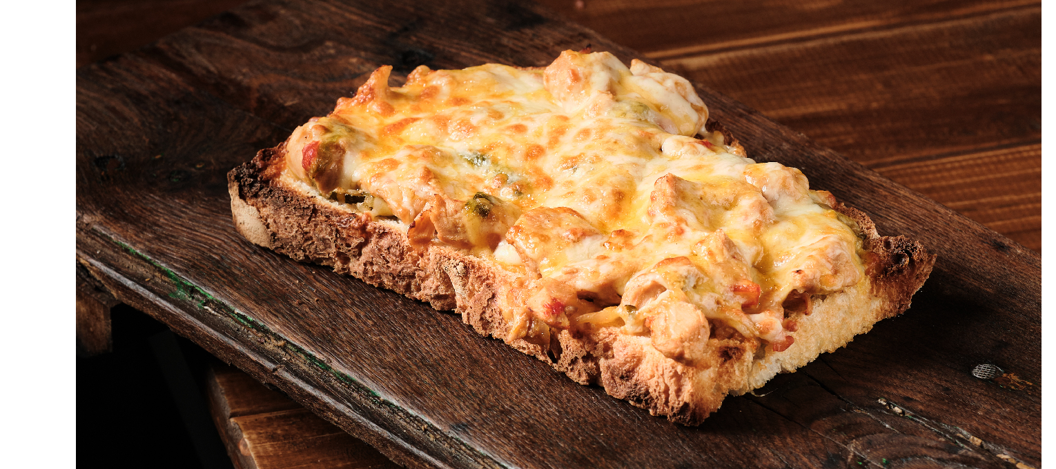 Tosta de pan payés con pollo thai gratinada.