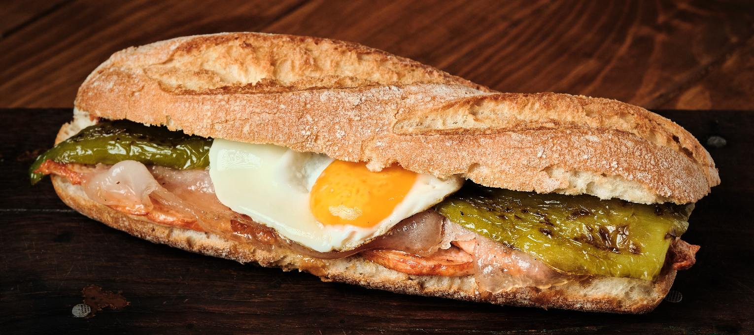 Bocadillo lomo, papada, ajoaceite, pimiento verde y huevo frito.