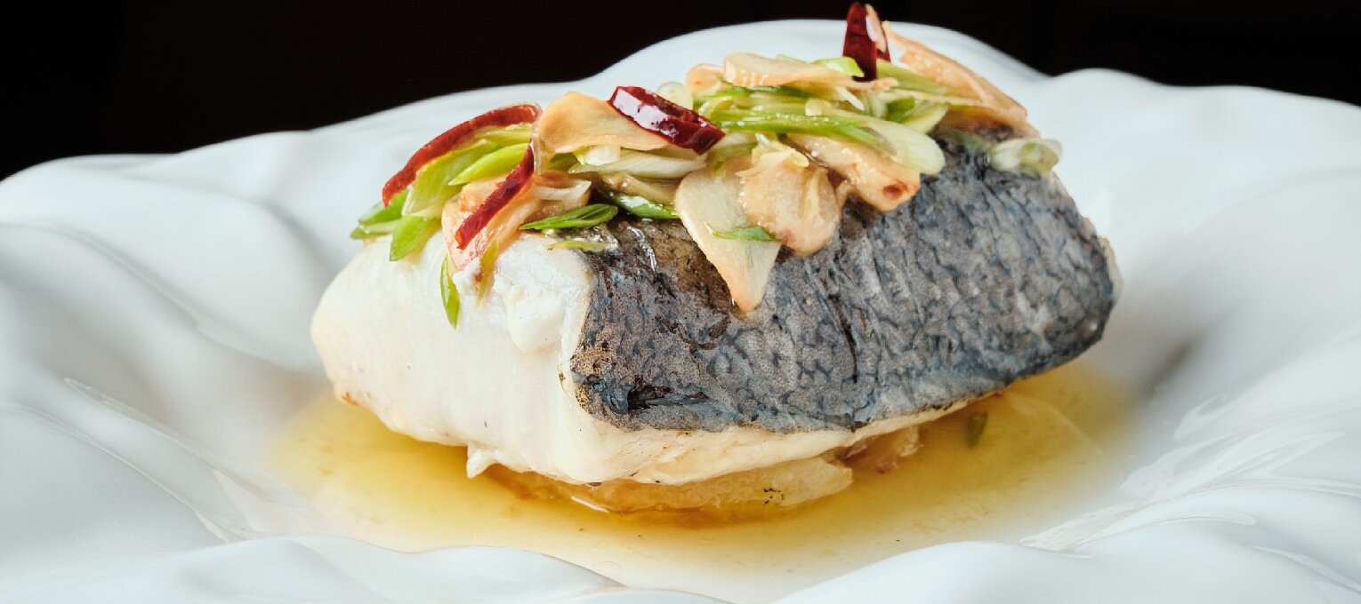 Merluza a la brasa y refrito verde de ajos tiernos.