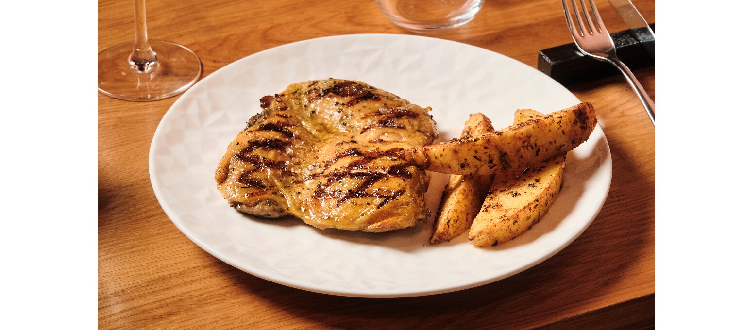 Muslo de pollo deshuesado a la brasa con salsa criolla y patatas.