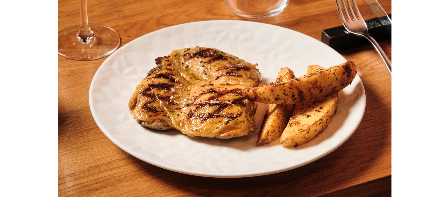 Muslo de pollo deshuesado a la brasa con salsa criolla y patatas.