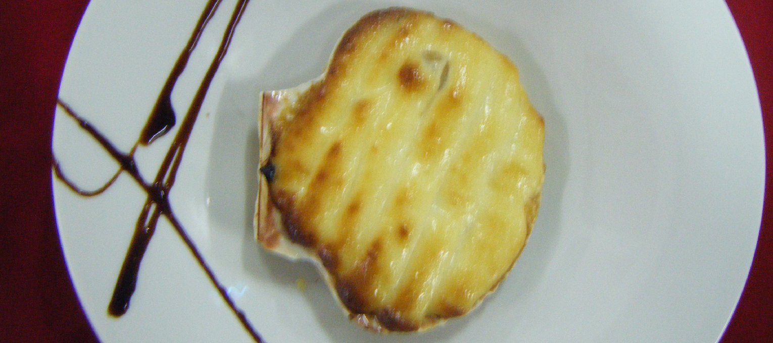 Vieira rellena de marisco con gratén de almendra. (Suplemento 1,5€).